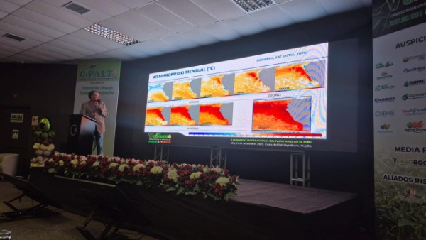 Speaker presenting ATMS agroclimatic projection charts on a giant screen during the CIPALTO 2026 technical conference.