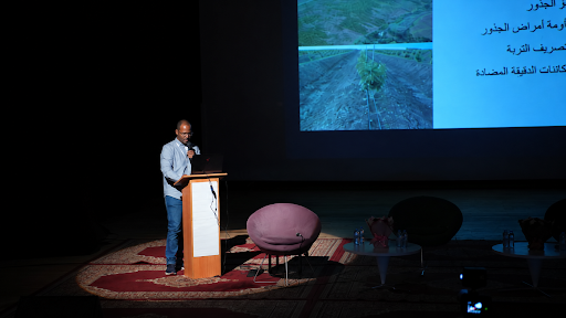 Ponente presentando avances técnicos sobre cultivo de aguacate en un podio frente a una pantalla durante la versión 2025 del evento.