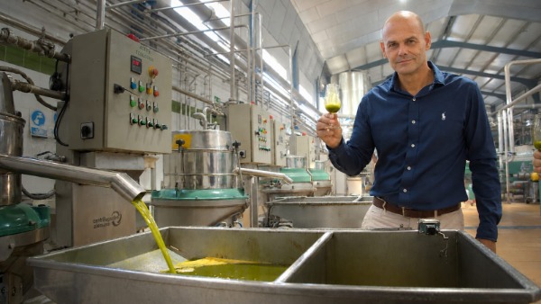 Enrique García, presidente de AOMA, sosteniendo una copa con aceite de aguacate en la planta de extracción. 